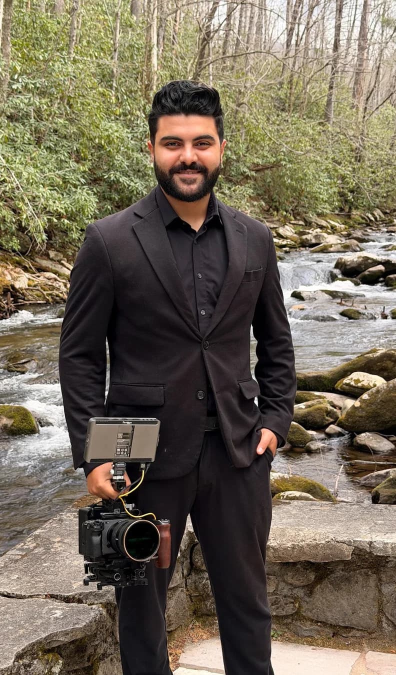 Bebo Nashat in a dark suit, his cinema camera in hand