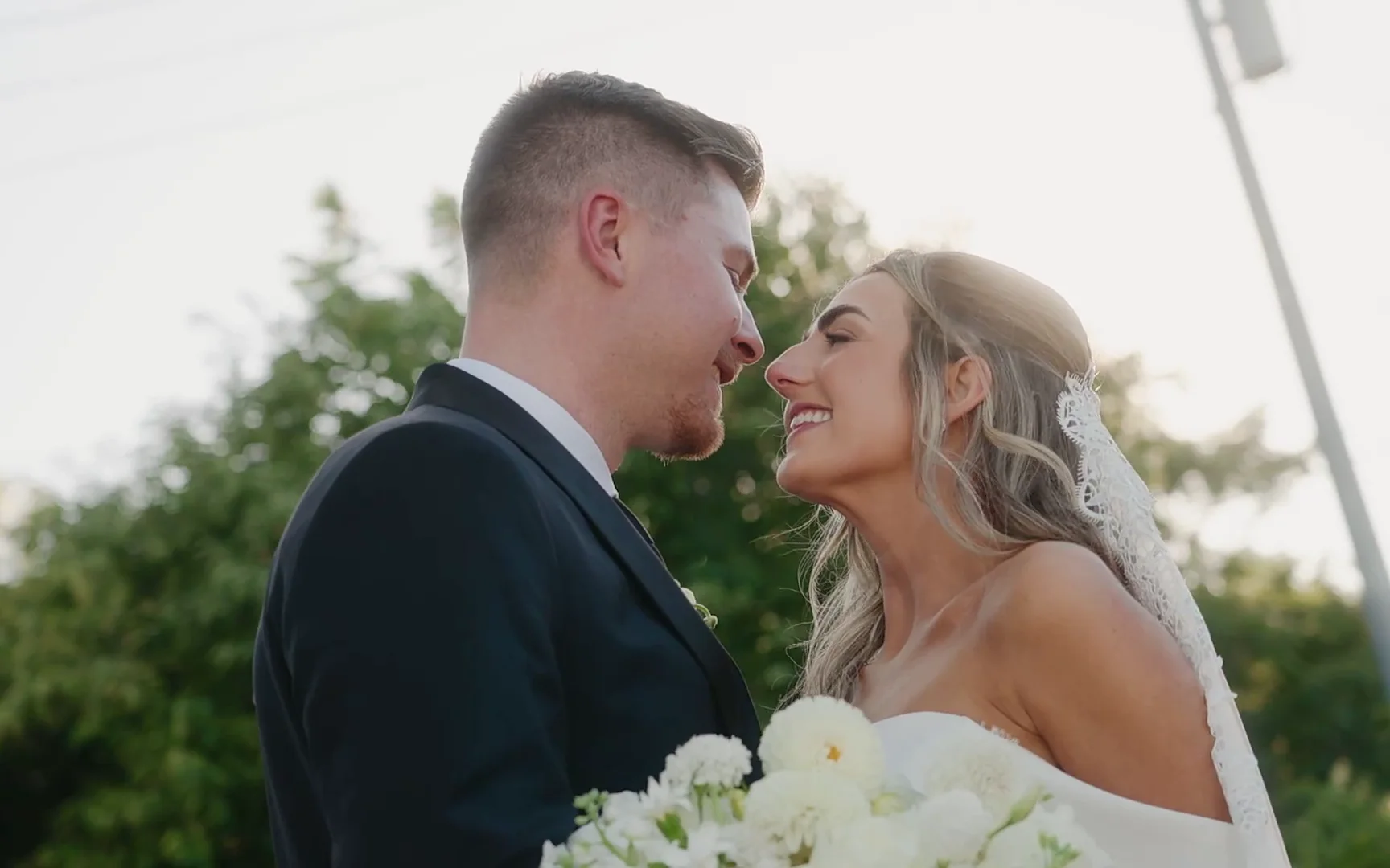 Rylee & Cory nose to nose in warm backlight, her veil catching the sun
