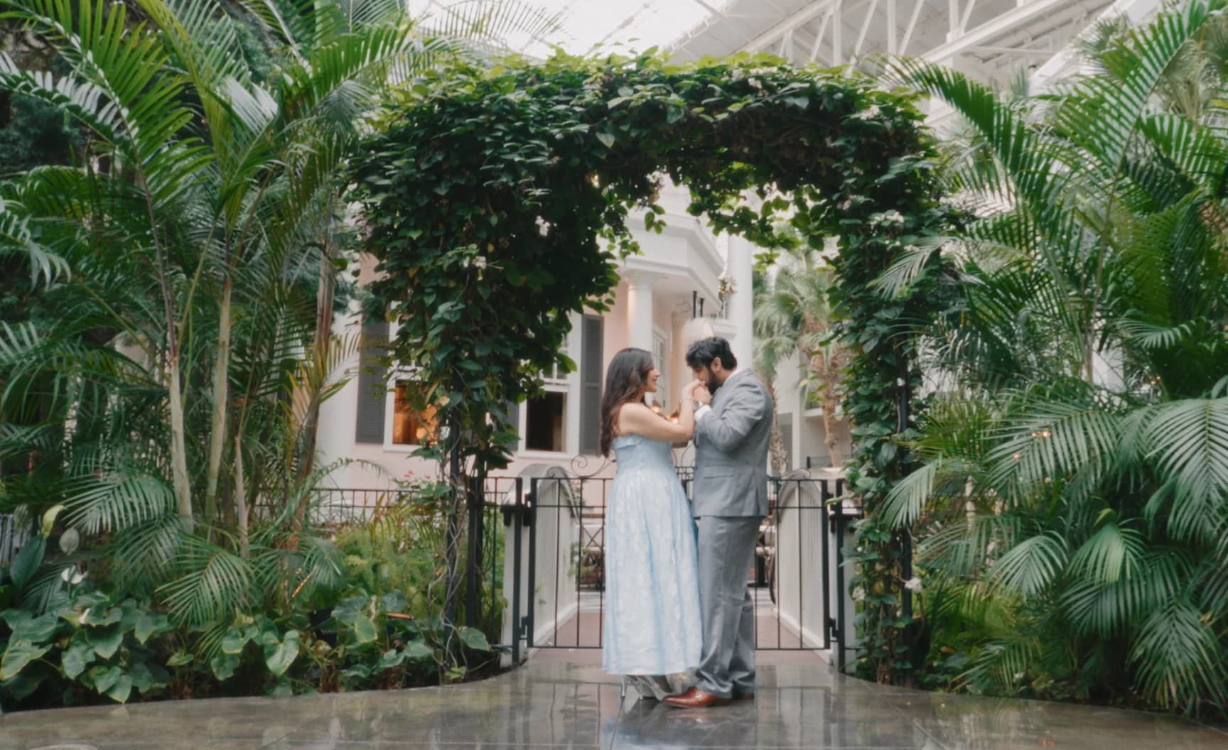 Mark and Clara embracing in a conservatory