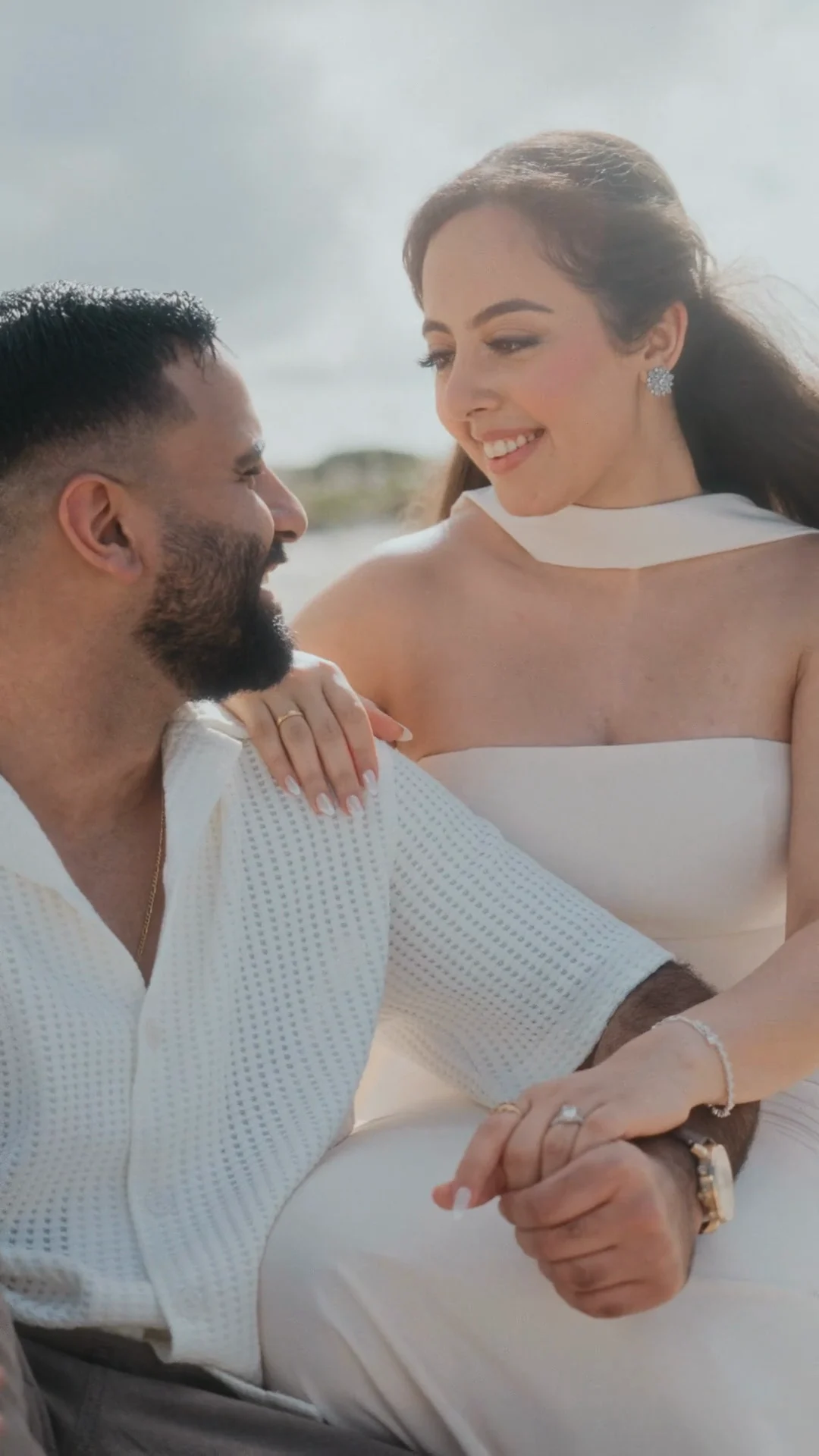 Kiro and Sandi laughing together on the beach, her ring in view